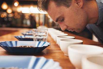 Man smelling aromatic coffee at a tasting