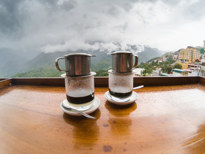 enjoying hot vietnamese black coffee on a restaurant terrace in Sapa
