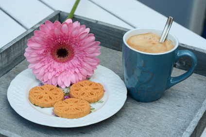 Koffie met koekjes met roze gerbera