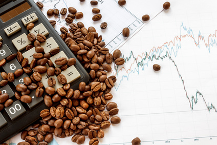 Coffee beans futures chart. Fresh coffee lies on graphics of quotations and the calculator. Top view
